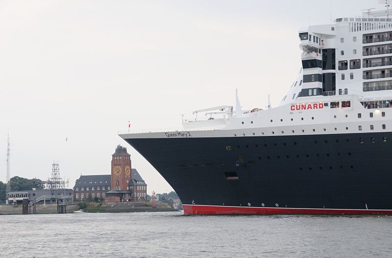 <title>Hafenfotografien. Die Queen Mary 2 kommt nach Hamburg - Schiffsbug vor der Lotsenstation Finkenwerder. Hamburger Hafenfotos -  Fotograf Christoph U. Bellin. 16_4656 Die Queen Mary 2 hat die Lotsenstation in Hamburg Finkenwerder erreicht; das historische Backsteingebude mit der grossen weit sichtbaren Uhr am Turm wurd um 1914 errichtet. Der Architekt war der damalige Oberbaudirektor Fritz Schumacher. Der hohe Bug des Passagieschiffes Queen Mary 2 hat gerade die Hhe des Hamburger Lotsenhauses erreicht. Entlag des Bubendey-Ufers fhrt ein kleines Sportboot, um den Luxusliner bei seiner Einfahrt in den Hamburger Hafen zu begleiten. www.fotograf-hamburg.de