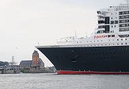 16_4656 Die Queen Mary 2 hat die Lotsenstation in Hamburg Finkenwerder erreicht; das historische Backsteingebude mit der grossen weit sichtbaren Uhr am Turm wurd um 1914 errichtet. Der Architekt war der damalige Oberbaudirektor Fritz Schumacher. Der hohe Bug des Passagieschiffes Queen Mary 2 hat gerade die Hhe des Hamburger Lotsenhauses erreicht. Entlag des Bubendey-Ufers fhrt ein kleines Sportboot, um den Luxusliner bei seiner Einfahrt in den Hamburger Hafen zu begleiten. www.fotograf-hamburg.de