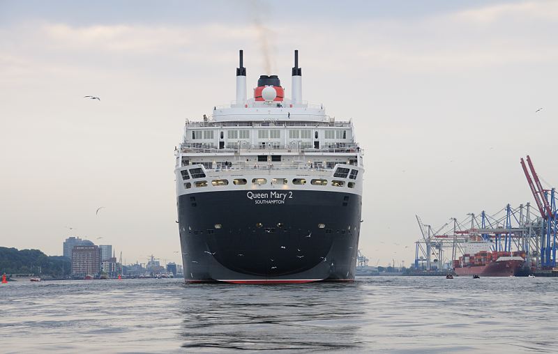 Schiffsfotografien. Passagierschiff Queen Mary 2 im Hamburger Hafen - Containerterminal. Hamburger Hafenfotos -  Fotograf Christoph U. Bellin. 18_4662 Die Queen Mary 2 auf der Elbe von Hamburg Oevelgnne; lks. der Museumshafen und das ehem. Khlhaus von Hamburg Neumhlen, das zu einer Seniorenresidenz umgebaut wurde. Rechts das HHLA Container Terminal Burchardkai mit seinen hohen Containerbrcken. Ein Containerfrachter liegt am Kai und wird beladen.  www.fotograf- hamburg.de