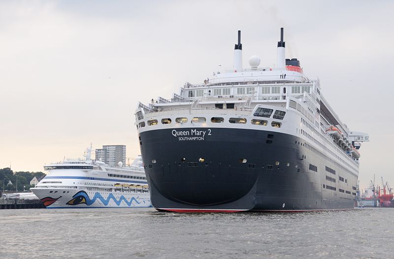 Schiffsbilder aus dem Hamburger Hafen. Die Queen Mary 2 im Hafen Hamburg - Kreuzfahrtterminal Altona / Aida Aura. Hamburger Hafenfotos -  Fotograf Christoph U. Bellin. 18_4662 Die Queen Mary 2 passiert bei ihrer Einfahrt in den Hamburger Hafen das Kreuzfahrt-Terminal Altona. Das Passagierschiff Aida Aura hat dort als erstes Kreuzfahrtschiff am gerade fertig gestellten Terminal fest gemacht; lks. im Hintergrund ein Frachter im Schwimmdock der Hamburger Werft Bohm & Voss. www.fotograf- hamburg.de