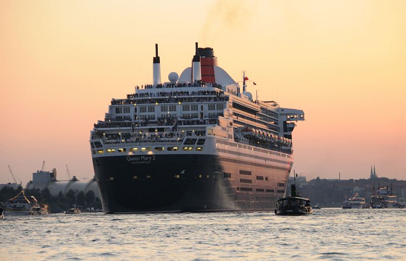 <title>Schiffsmotive aus Hamburg. Die Queen Mary 2 luft am Abend aus - Sonnenuntergang, Begleitboote auf der Elbe. Hamburger Hafenfotografie Christoph U. Bellin.  28_4955 Die Queen Mary 2 fhrt in den rot gefrbten Hamburger Abendhimmel; Begleitboote verabschieden das Kreuzfahrtschiff - Passagiere stehen auf den Decks und beobachten die Abfahrt. www.fotograf- hamburg.de