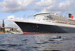 8565 Bug der Queen Mary 2 - im Hintergrund die St. Michaeliskirche, dem Wahrzeichen der Hansestadt Hamburg. Kleines Motorboot mit Aussenbordmotor in Fahrt auf der Elbe.