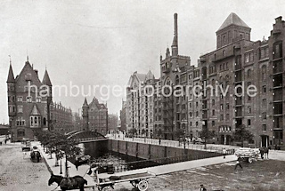 0148_17_1_27  Auf der St. Annenbrcke fahren Pferdefuhrwerke; eines ist mit Scken beladen; re. die Blcke Q + R am St. Annenufer, eine Hieve Scke wird gerade vom Speicherboden auf ein Fuhrwerk herunter gelassen. Im Hintergrund der Block G hinter der Neuerwegsbrcke am Pickhuben  - links der Block 0 mit den Neugotischen Giebeltrmen. Die Hamburger Speicherstadt wurde ab 1883 errichtet.