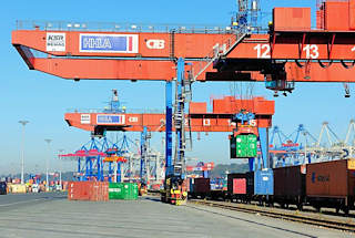 0813 Portalkräne über den Gleisen auf dem Terminalgelände Burchardkai - ein Container wird auf den Güterwaggon abgesenkt.