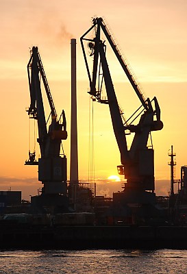 011_15328 - Sonnenuntergang im Hamburger Hafen; zwei Hafenkrne und ein Schornstein im Gegenlicht.