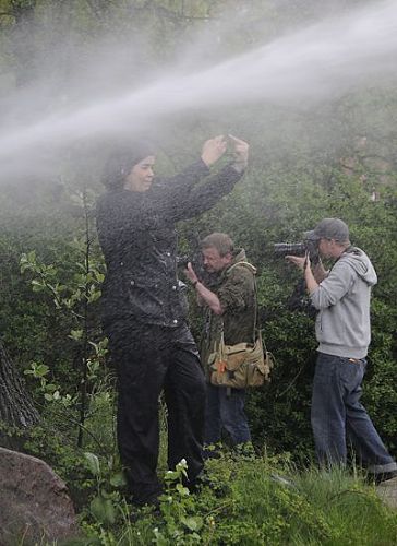 011_17489 - eine Demonstrantin steht im Strahl des Wasserwerfers und zeigt den vorbei marschierenden Neonazis mit beiden Hnden: FUCK YOU! Im Hintergrund Fotografen bei der Arbeit.