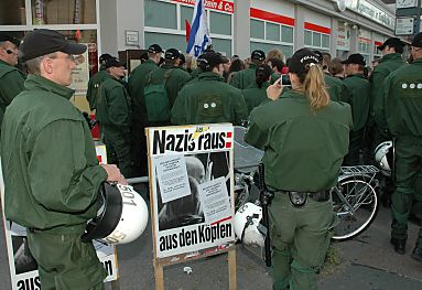 011_14231 - die Polizei zeigte Strke indem sie die Nazi-Veranstaltung mit 1300 Polizisten und Polizistinnen schtze: protestierende Anwohner werden massiv zurckgedrngt; Polizist mit Helm - Protestschild: Nazis raus : aus den Kpfen.