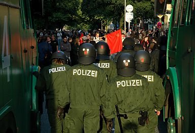 011_14233 - ein Polizei-Eingreiftruppe steht mit Schlagstock ausgerstet zwischen zwei Wasserwerfern Demonstranten gegenber, die gegen die Neo-Nazi-Veranstaltung demonstrieren.