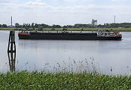 11_17525 Das Binnenschiff ALBATROS fhrt auf der Alten Doveelbe in Hhe vom  Moorfleeter Deich; eine Duckdalbe aus Holz spiegelt sich im Wasser, im Vordergrund Schilf am Ufer. Das Binnenschiff ALBATROS hat eine Lnge von 80,00m und eine Breite von 9,50m - ca. 1400 to kann das Motorschiff als Ladung aufnehmen. Im Hintergrund links ein Polygon der Autobahnbrcke A 1 ber die Norderelbe; recht ein hohes Windrad, das bei Hamburg - Georgswerder steht.